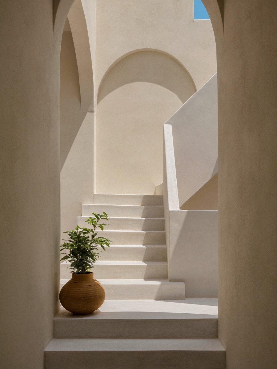 Sunlit white Mediterranean staircase with arch shadows