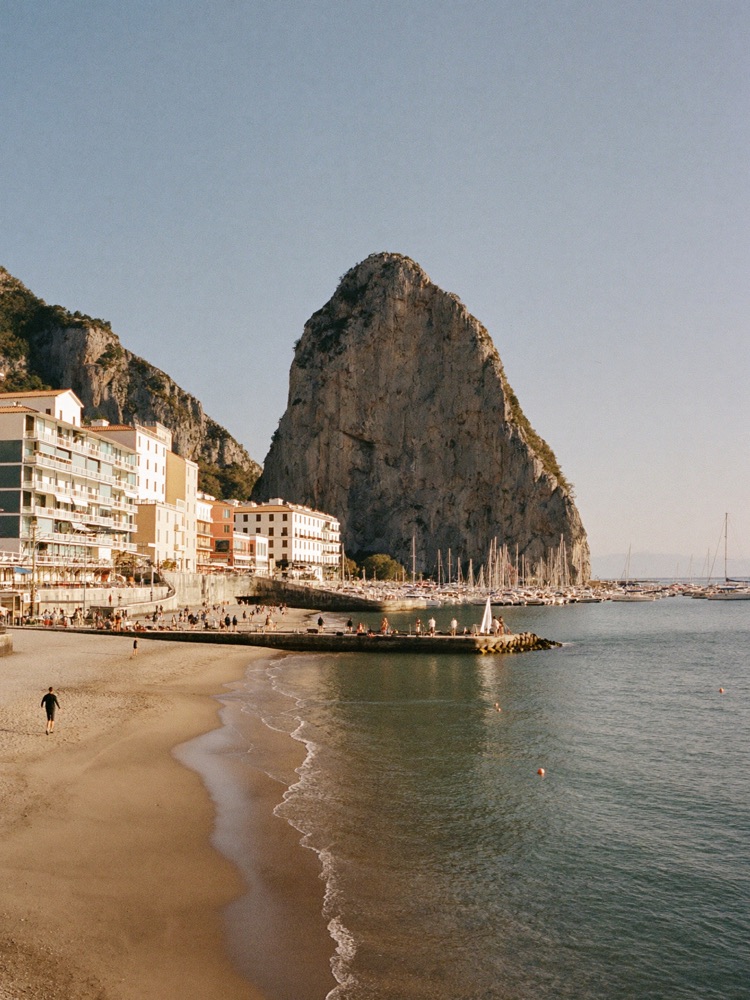 The Pe&ntilde;&oacute;n de Ifach rock rising over the beach and marina of Calpe